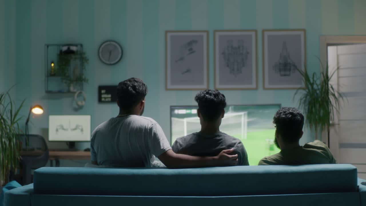 Football fans celebrating goal in living room