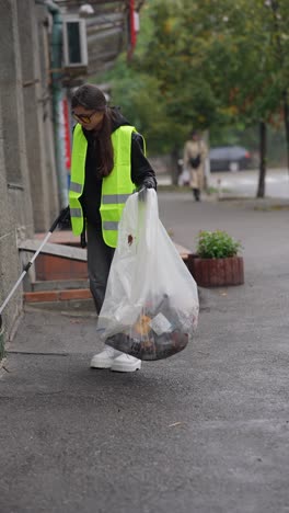 mujer limpiando la basura en la calle
