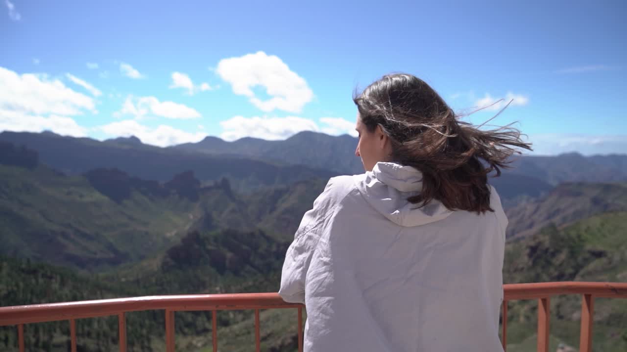 Woman looking at mountains landscape at viewpoint in Artenara, Gran Canaria, Spain