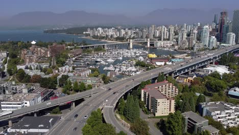 Panorámica-Aérea-3-4-Sobre-La-Comunidad-Comercial-Residencial-De-La-Isla-Granville-Superior-Y-El-Puente-Que-Conduce-Al-Centro-De-La-Ciudad-Sobre-Los-Clubes-Náuticos-Estacionados-De-Yates-De-False-Creek-En-Una-Exuberante-Tarde-Pandémica-De-Cierre-De-Verano