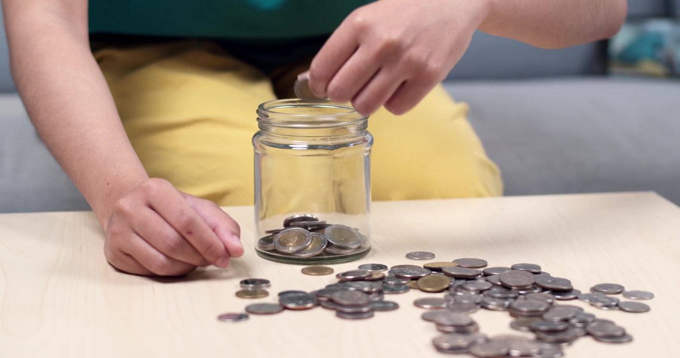 A child carefully counts coins promoting financial literacy and saving habits in a cozy home environment.