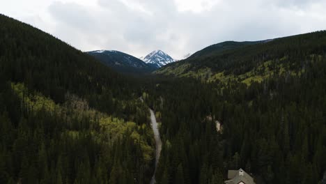 Disparo-De-Un-Dron-Empujando-Lentamente-Hacia-James-Peak-Con-Bosques-Verdes-En-Primer-Plano