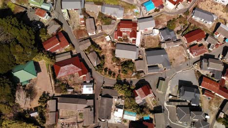 overhead top down aerial flight over small japanese village with houses and road