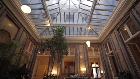 revealing shot of a small table in a stunning conservatory with a large skylight