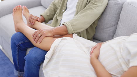 embarazada, mujer y hombre masajeando los pies