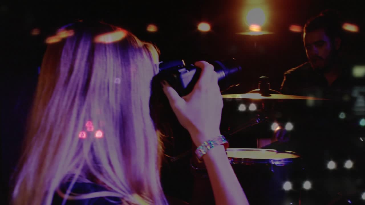 Female photographer raising DSLR capturing music set, framing vocalist singing with bokeh overlays