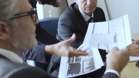 mature businessmen giving papers with slides