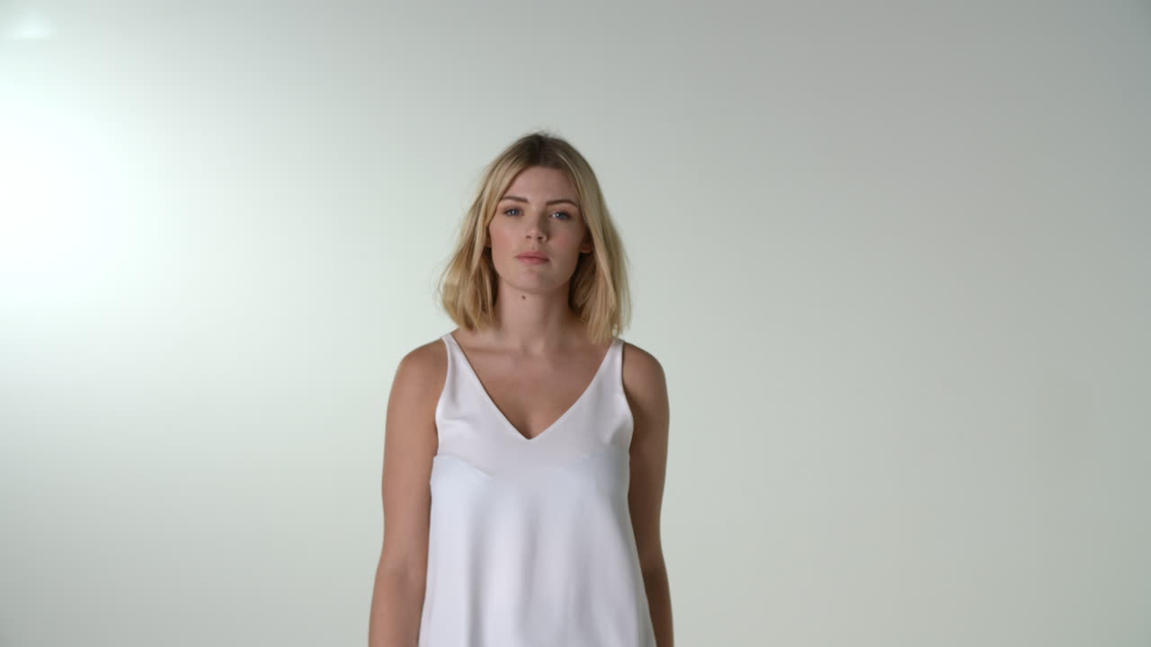 una joven rubia camina hacia la cámara, en foco, en cámara lenta.