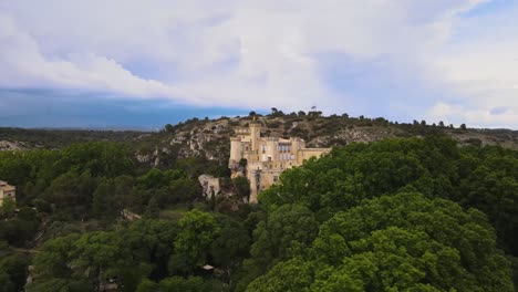 chateau comtal aerial trucking pan reveal behind trees to historic castle towers and walls