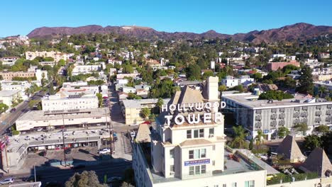 aerial over the hollywood tower hotel reveals the griffith park observatory and hollywood sign distant 1