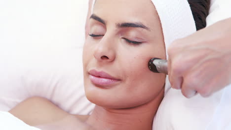 relaxed brunette having facial treatment