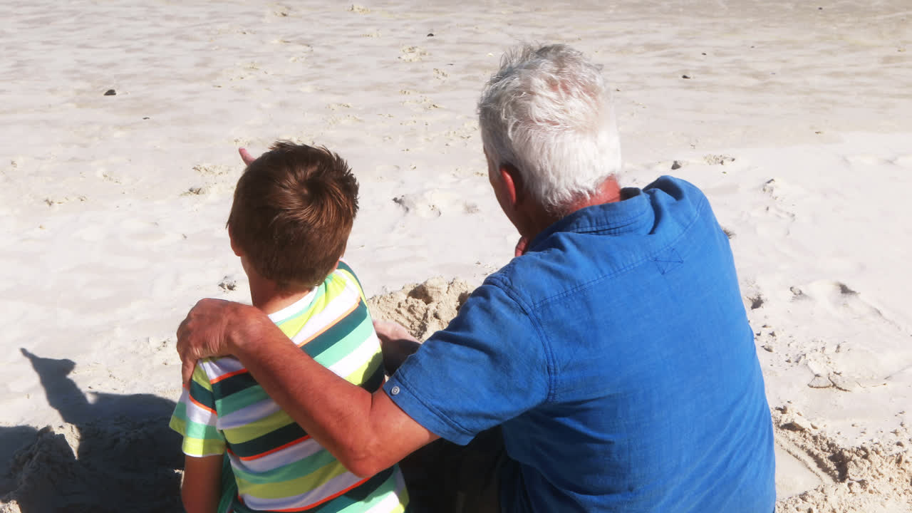 abuelo y nieto interactuando entre sí en la playa