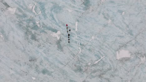 aerial top view over people hiking on the ice surface of virkisjokull glacier, iceland