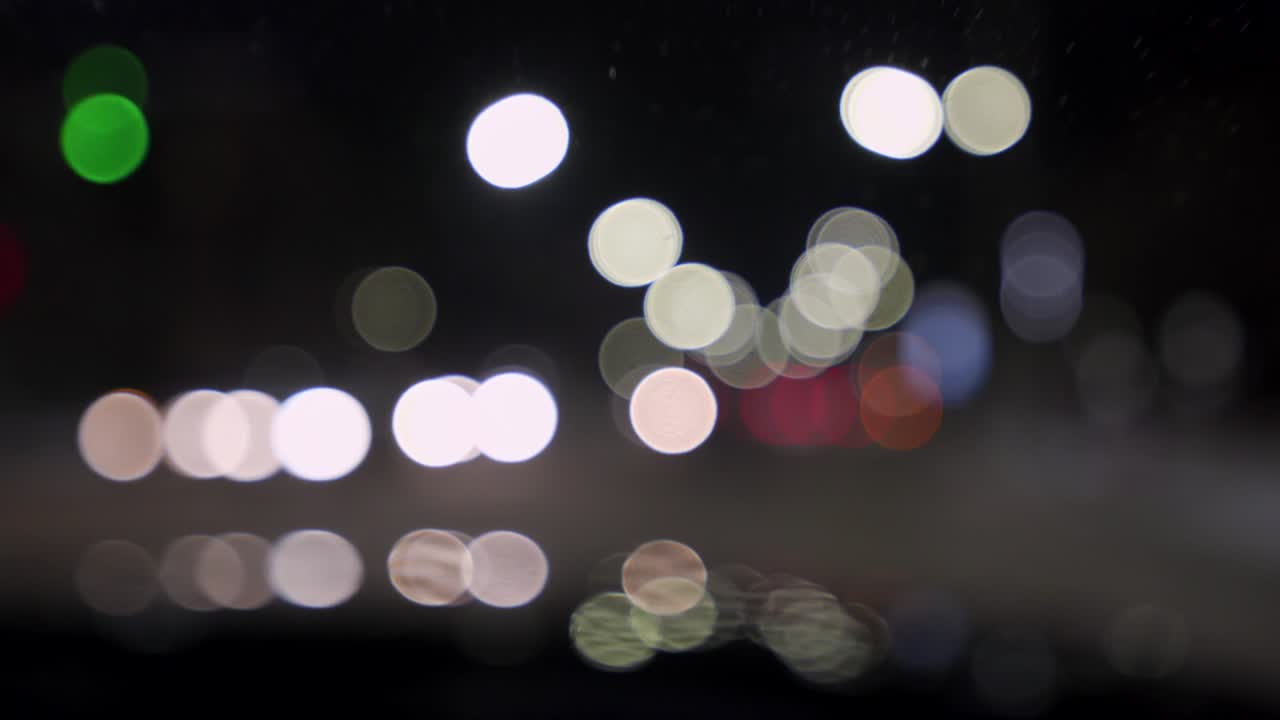 bokeh de automóviles y semáforos por la noche. bokeh de tráfico nocturno de una pequeña ciudad europea. bokeh redondo y colorido que brilla de las luces de los automóviles en el atasco de tráfico en la calle de la ciudad