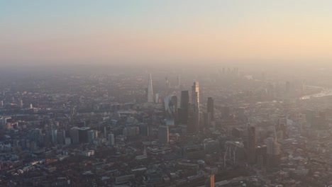 Un-Dron-Lento-Avanza-Hacia-Los-Rascacielos-De-La-Ciudad-De-Londres-A-La-Hora-Dorada-Del-Atardecer