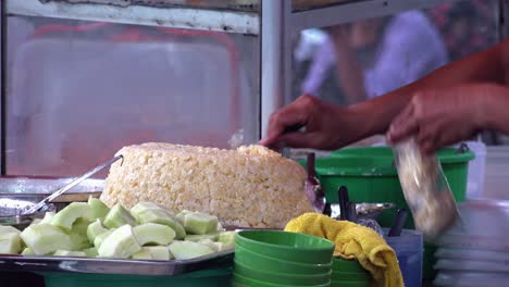 vendedor embolsando un poco de arroz pegajoso en un puesto en el mercado