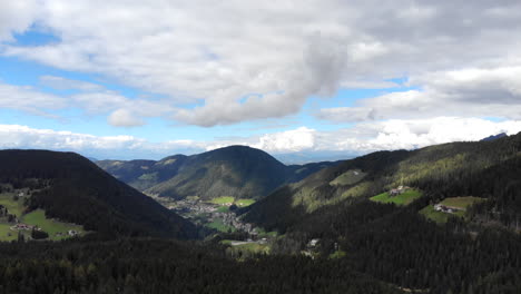 Vista-Aérea-De-Drones-De-360-4k-De-Las-Montañas-Dolomitas-De-Los-Alpes-Italianos-En-Un-Día-Nublado-Con-árboles-Y-Ciudades-Enclavadas-En-Valles