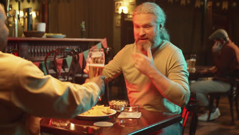 hombre saludando a su amigo en el pub