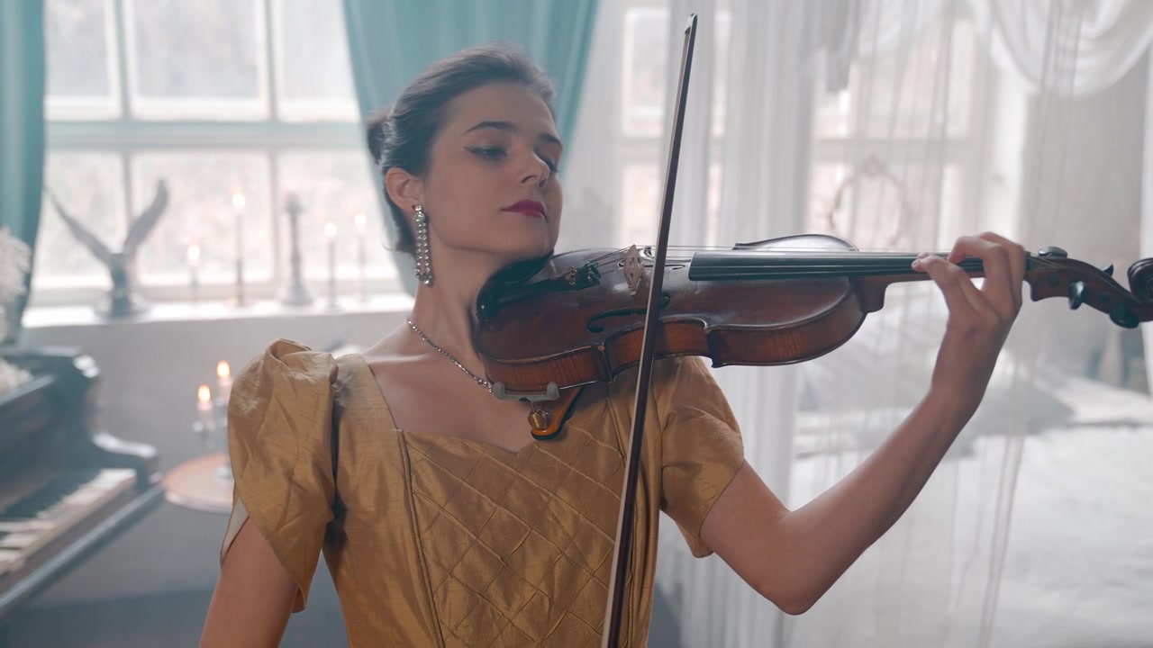 Giovane donna elegante che suona il violino in una stanza vintage