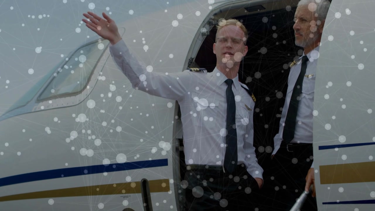 Speckles thinning, airline crew stepping onto stairs one signaling ramp other holding rail watching