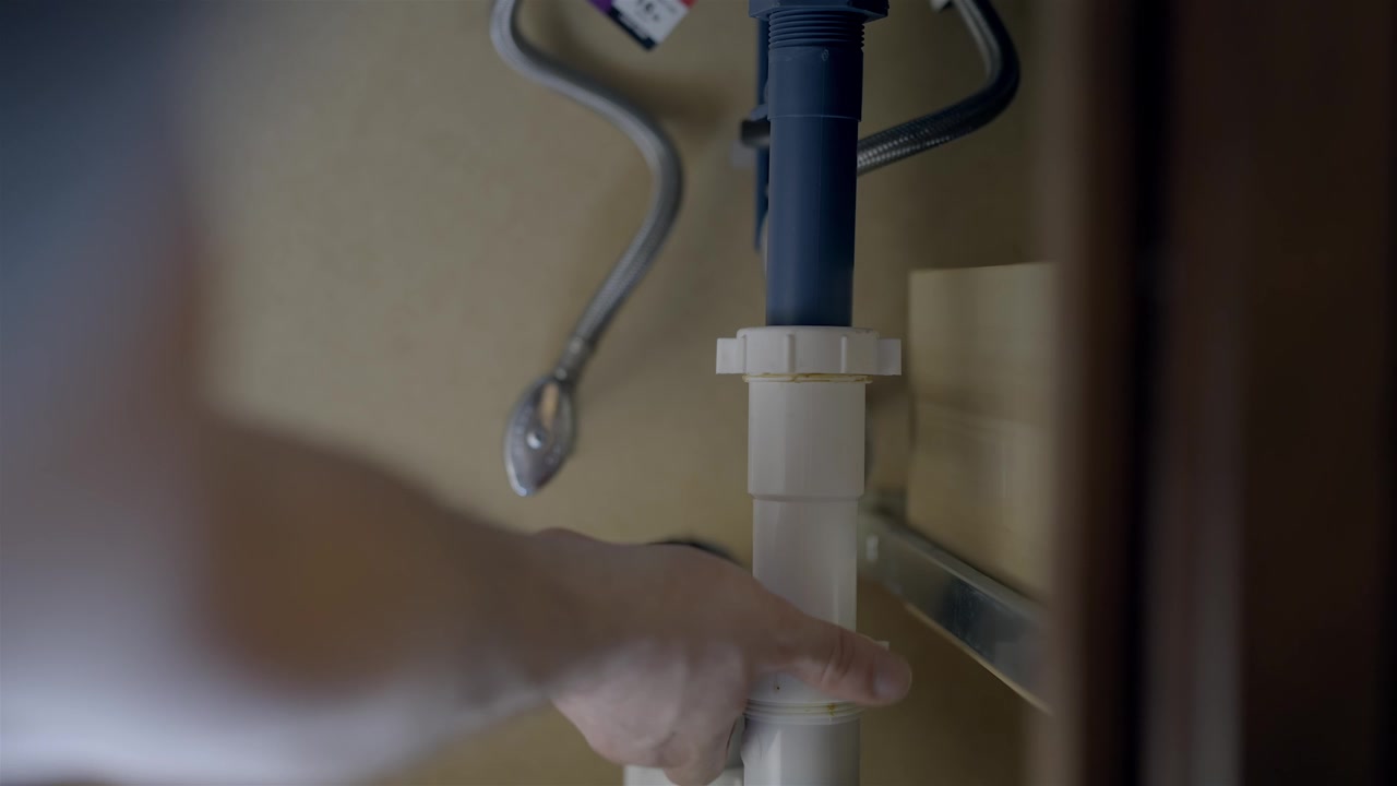 Close up View Hands Adjusting Water Lines Under Sink
