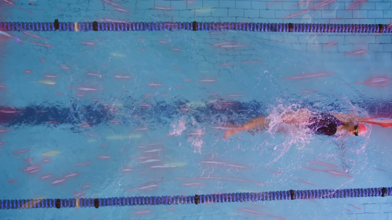 After pushing off pool wall, swimmer doing front crawl in sports training lane generating bubbles