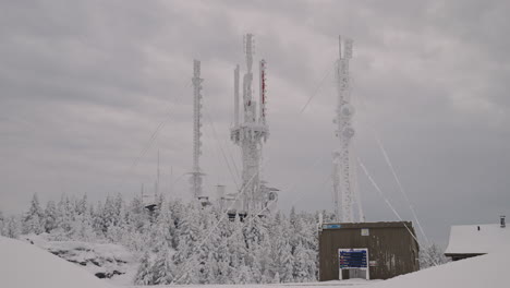 Communications-Antenna-Tower-Covered-In-Snow-At-Mount-Orford,-Quebec,-Canada-During-Wintertime---zoom-out-shot