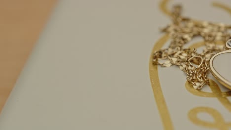 macro reveal of a beautiful golden necklace with a drop shaped locked