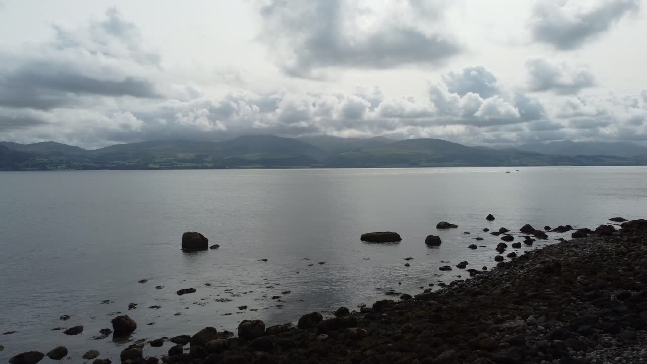 amanecer de mal humor niebla cordillera galesa vista aérea volando a través de las aguas tranquilas del océano con vistas a un paisaje majestuoso y pacífico