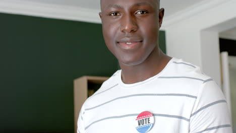 young african american man wearing a 'vote' badge