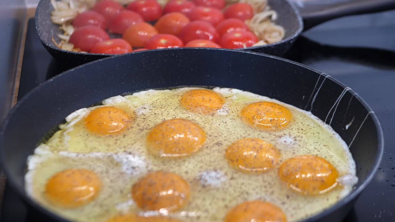 slow motion cooking home made breakfast with full pan of eggs, tomatoes, onions for a big family