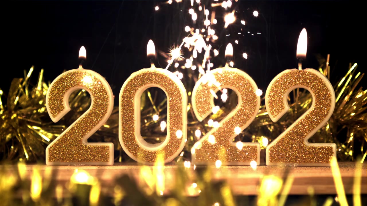Candele dorate del 2022 che bruciano con stelle filanti festive
