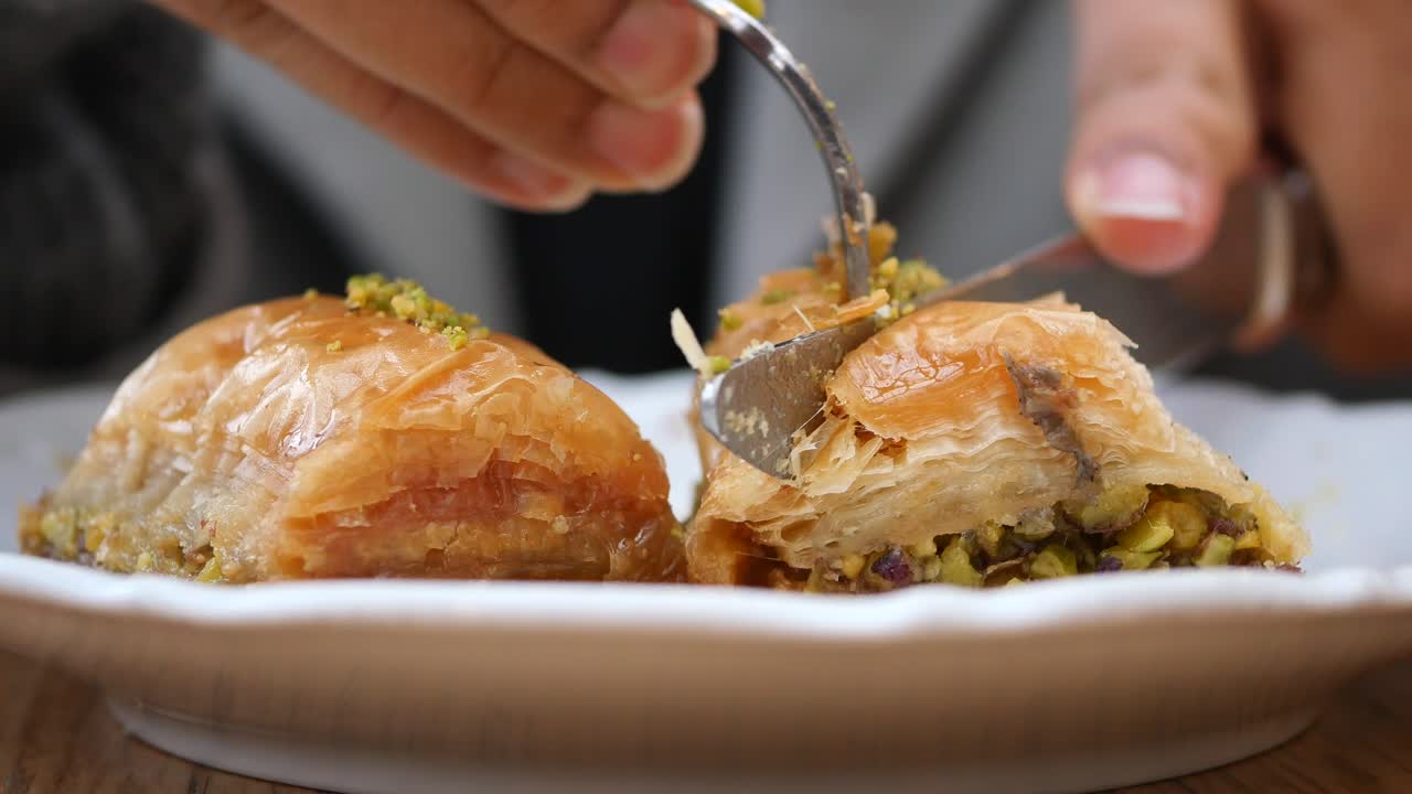 Primo Piano di una Mano con una Forchetta che Taglia un Pezzo di Baklava