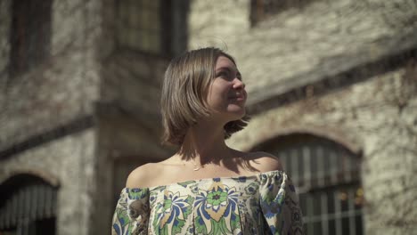 A-dynamic-handheld-footage-of-a-young-woman-standing-outdoors-at-sunlight-while-looking-around-and-enjoying-the-view