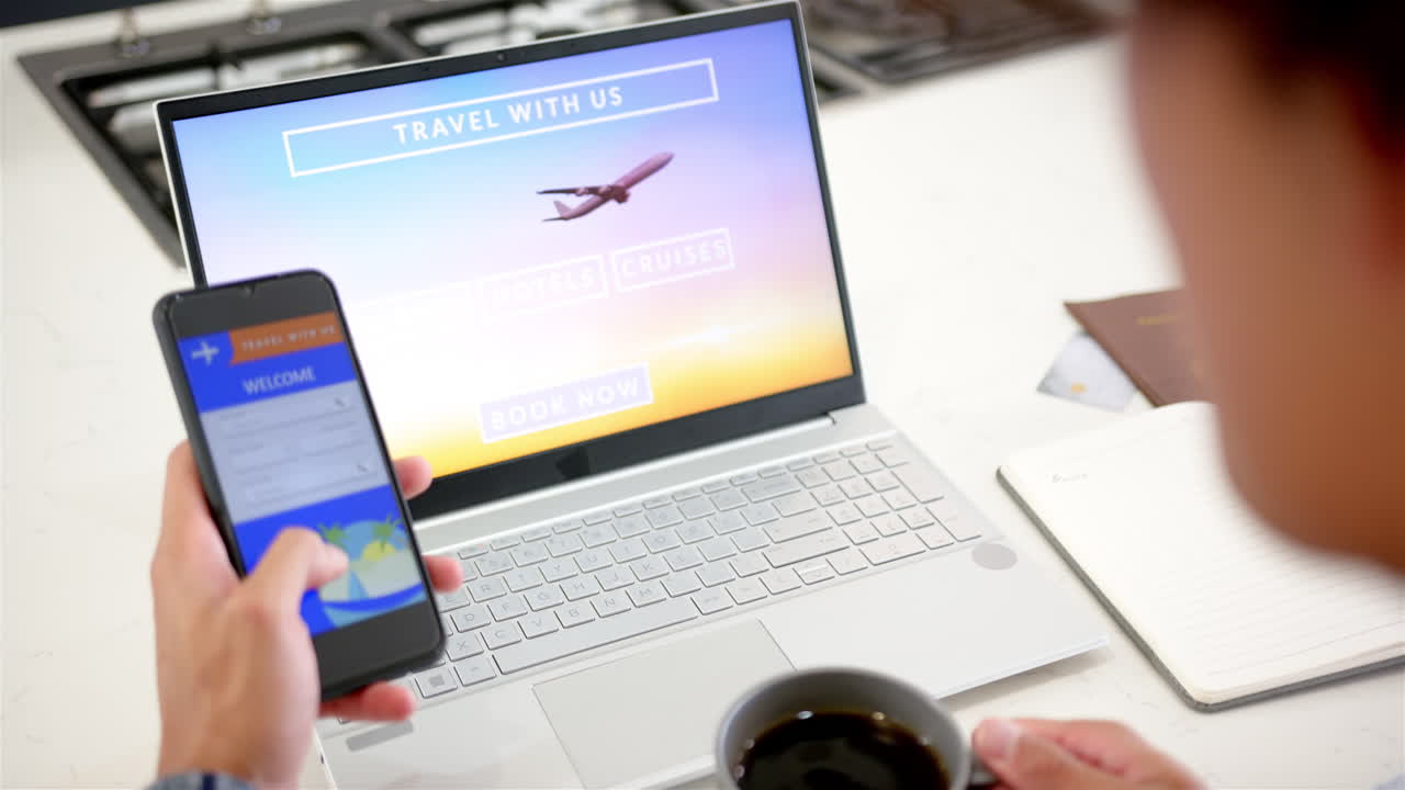 Booking travel online, man using smartphone and laptop while drinking coffee