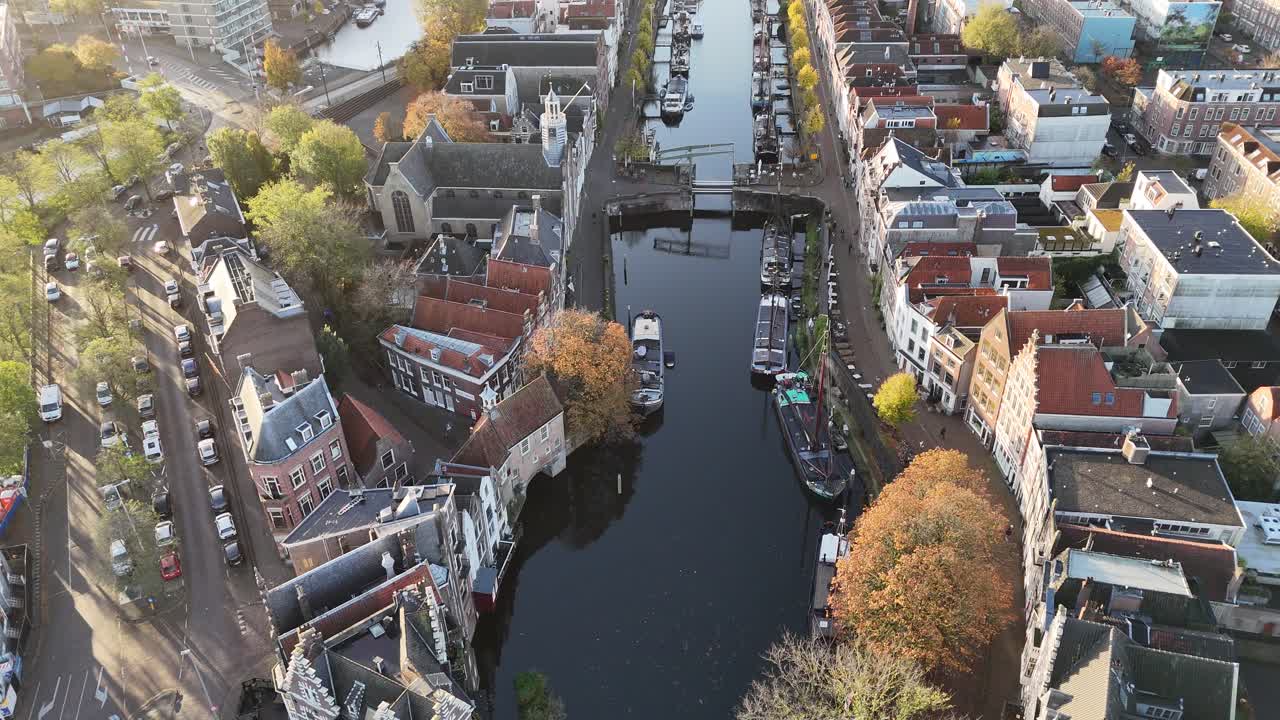 Aerial drone video of Rotterdam, Netherlands, featuring a picturesque canal, unique architecture, and vibrant autumn trees along the water—capturing the charm and beauty of this dynamic European city