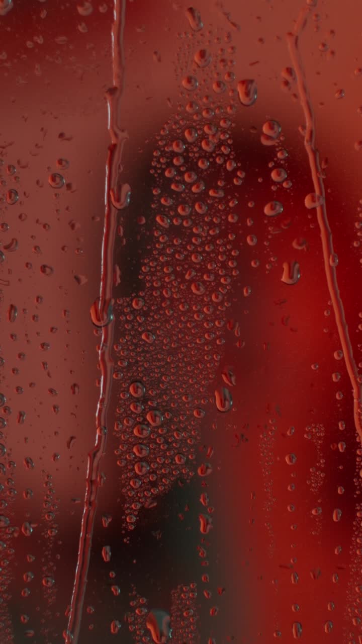 Gotas de agua sobre vidrio rojo