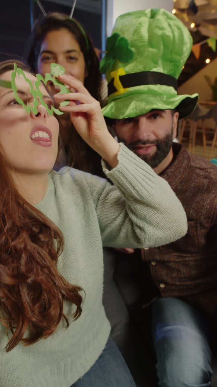 Video Verticale di Amici che si Vestono a Casa o al Bar, Festeggiando a una Festa di San Patrizio, in Posa per un Selfie al Telefono in Tempo Reale 1