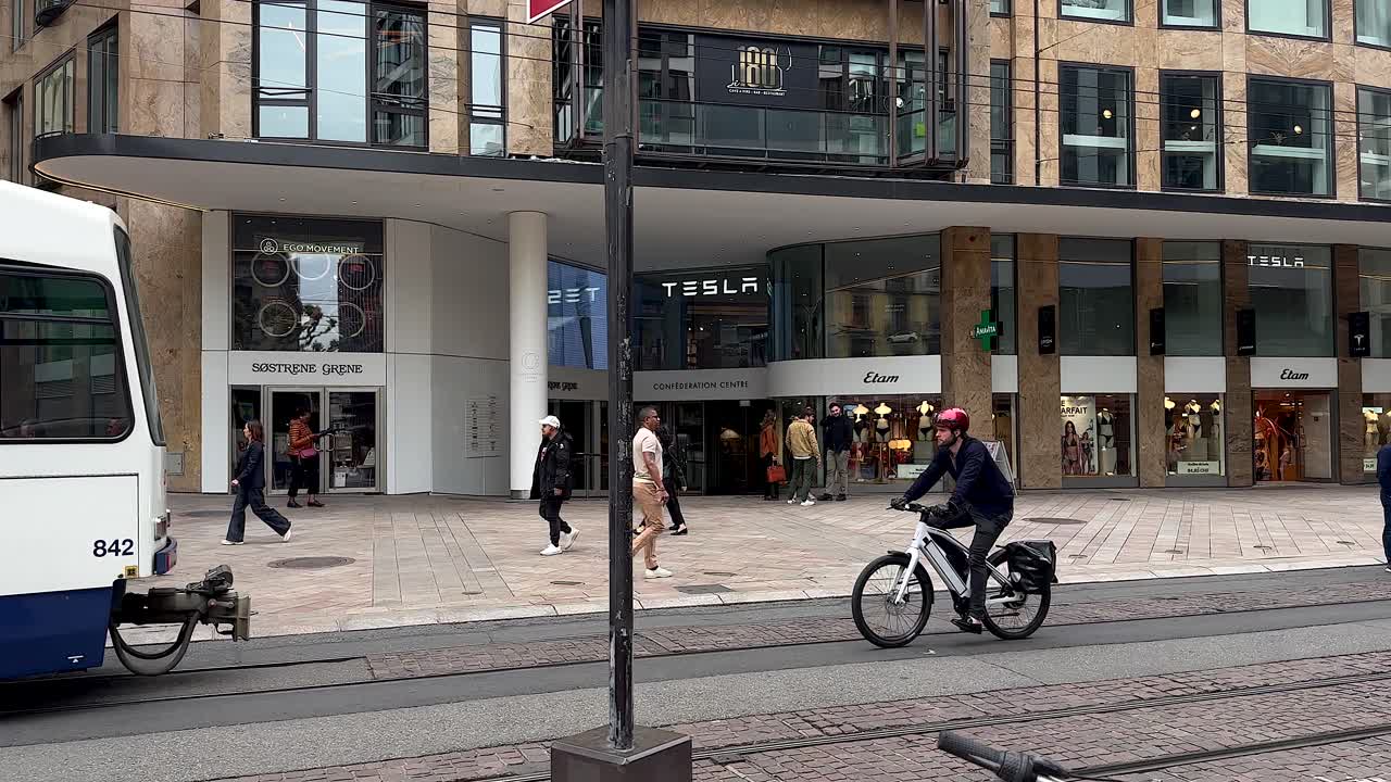 Tesla Stop in city center of Geneve of Switzerland. Walking pedestrian with railroads. Slow motion shot.