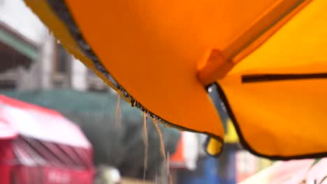 rain dripping from an orange umbrella