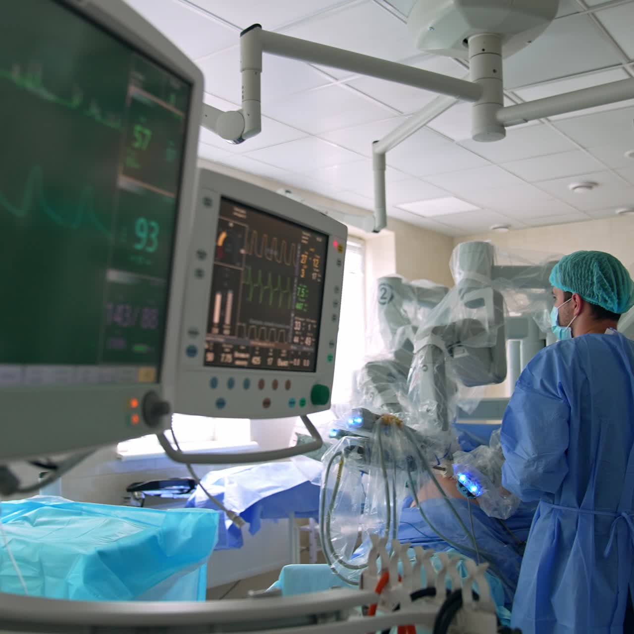 Medico concentrato in piedi vicino al robot chirurgico Da Vinci in sala operatoria. Filmato che mostra le attrezzature avanzate della sala operatoria