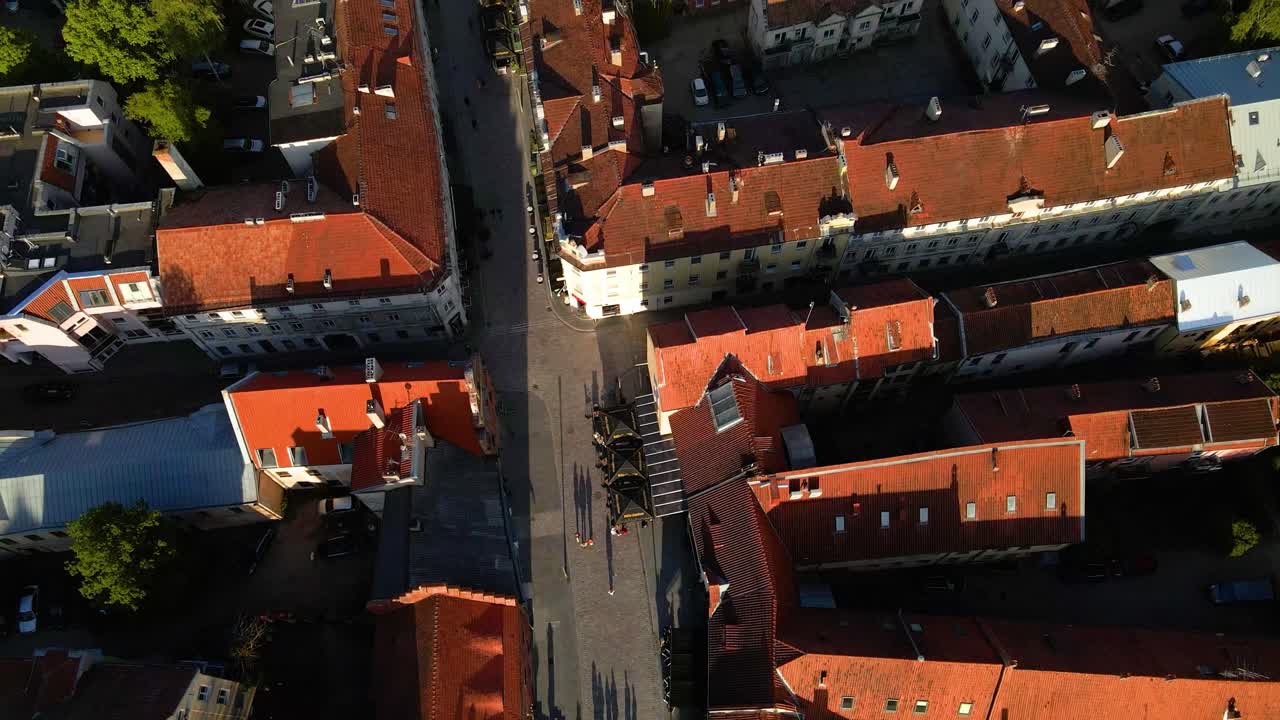 toma aérea de casas históricas y calles estrechas en el casco antiguo de kaunas junto al río nemunas en lituania en una noche soleada, toma de arriba hacia abajo