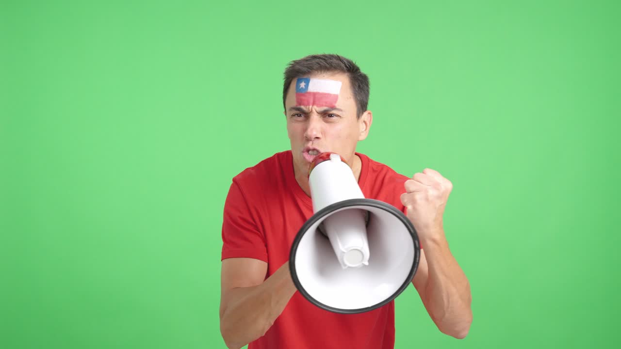 Excited man with chilean flag on face using a megaphone