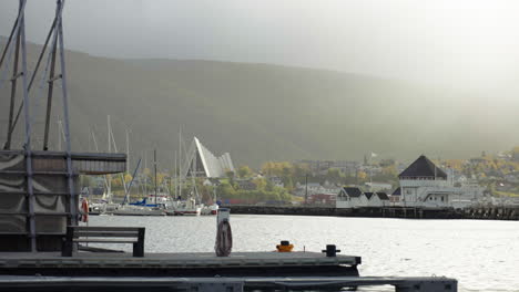 distant view of arctic cathedral from the port of tromso on a misty morning in norway