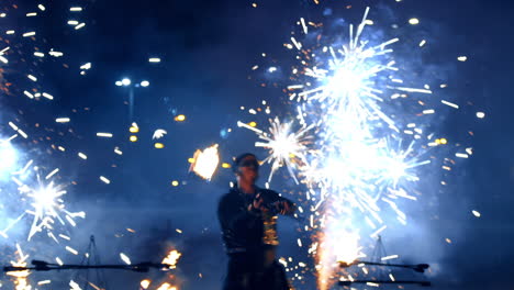 couple of actors showing the fire spectacle. man uses the firework prop and woman spits the fire flame.