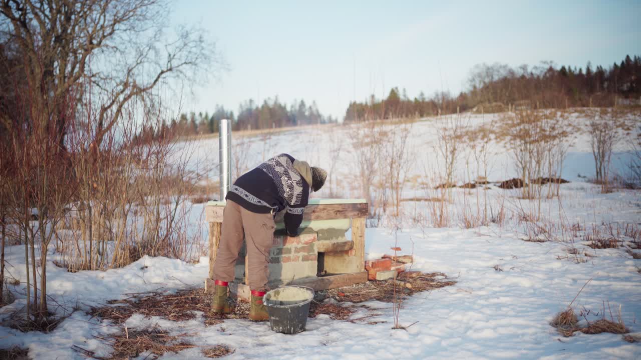 Ein Mann arbeitet draußen im Winter an einem DIY-Whirlpool