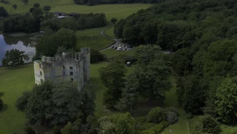 moody, dark, evening drone flight over old wardour castle ruins near a lake