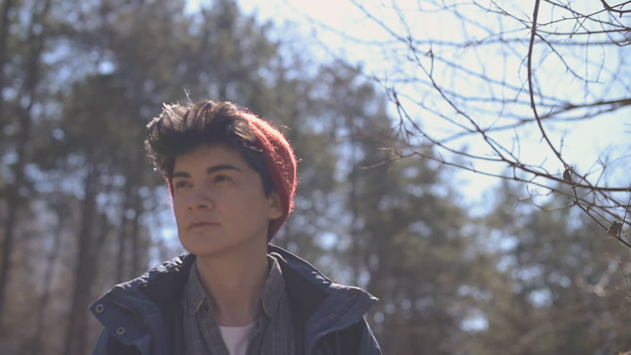 짧은 머리를 가진 여자는 숲에서 산책