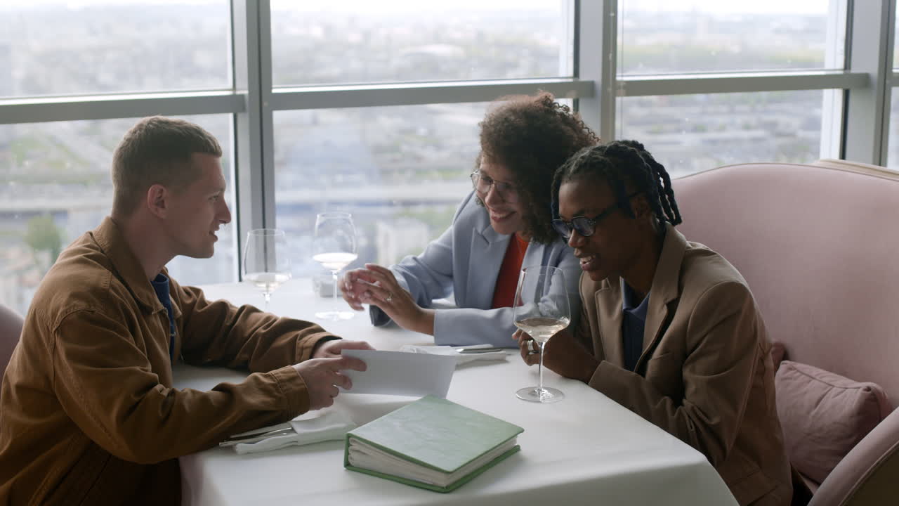 Friends having lunch in a restaurant with a view