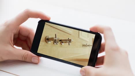 persona que sostiene un teléfono inteligente con interiores de baño modernos mostrados en la pantalla